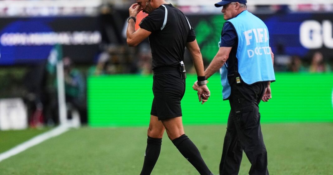 El árbitro argentino Facundo Tello siendo atendido en el campo de juego tras sufrir una lesión.