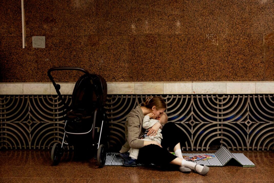 Madre abrazando a su bebé para protegerlo durante una alerta aérea en una estación de metro de Kiev.
