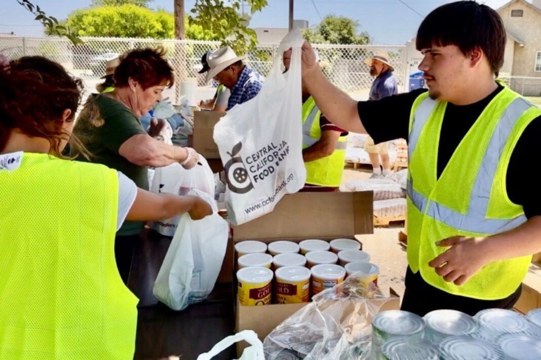 Voluntarios repartiendo cajas de alimentos en un centro comunitario.