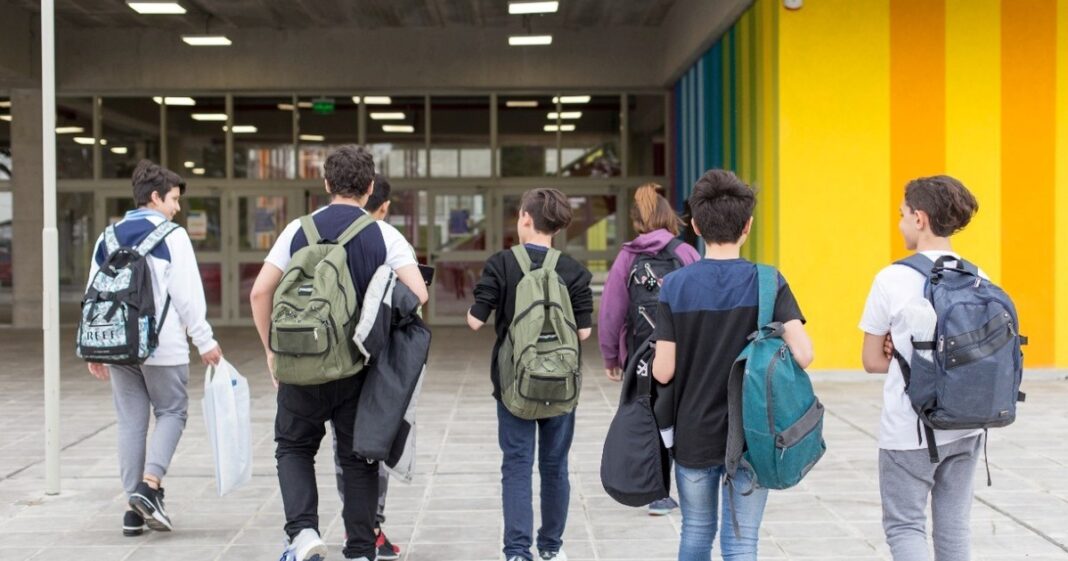 Gráfico que muestra el porcentaje de ausentismo escolar en Argentina, con estudiantes frente a una escuela