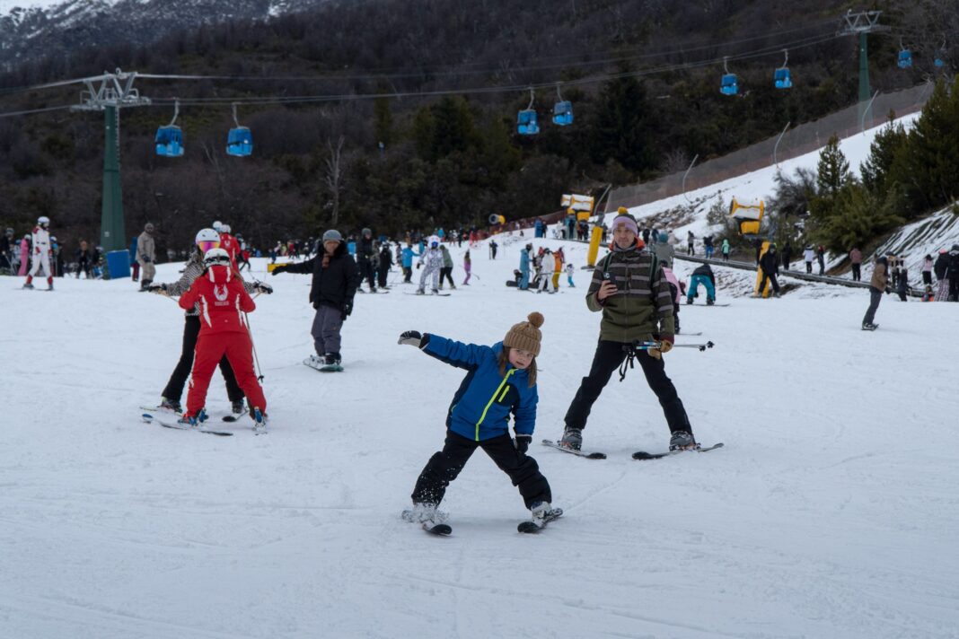 Vista aérea del Cerro Catedral, Bariloche, cubierto de nieve con esquiadores en sus pistas.