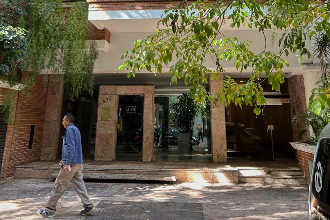 Ilustración de un edificio de departamentos con símbolos de justicia y dinero.