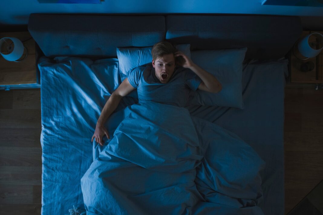 Persona durmiendo plácidamente en una cama, ilustrando un descanso de calidad.