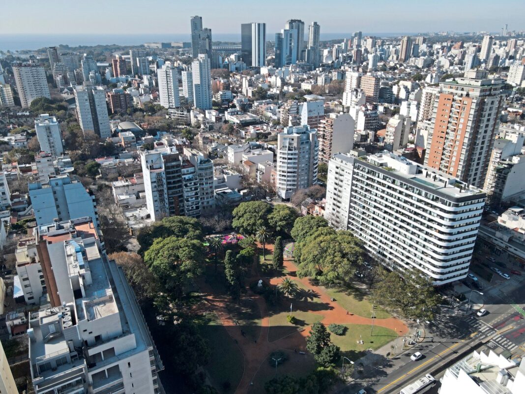 Persona revisando una liquidación de expensas y calculadora sobre una mesa