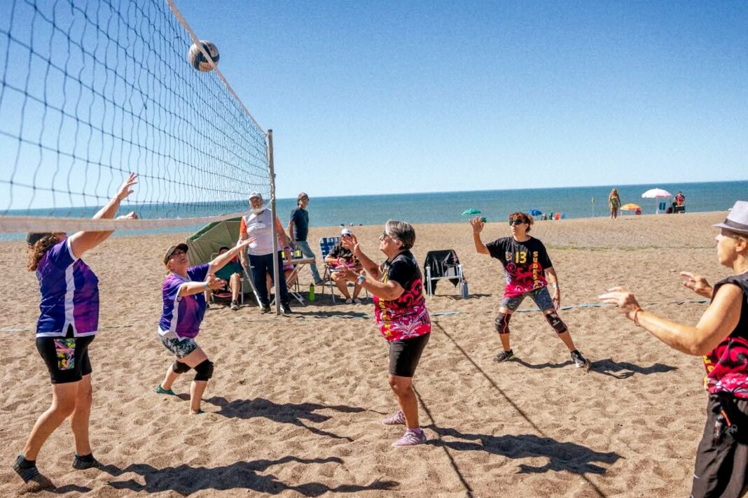 Grupo de adultos mayores jugando al newcom en un gimnasio municipal.