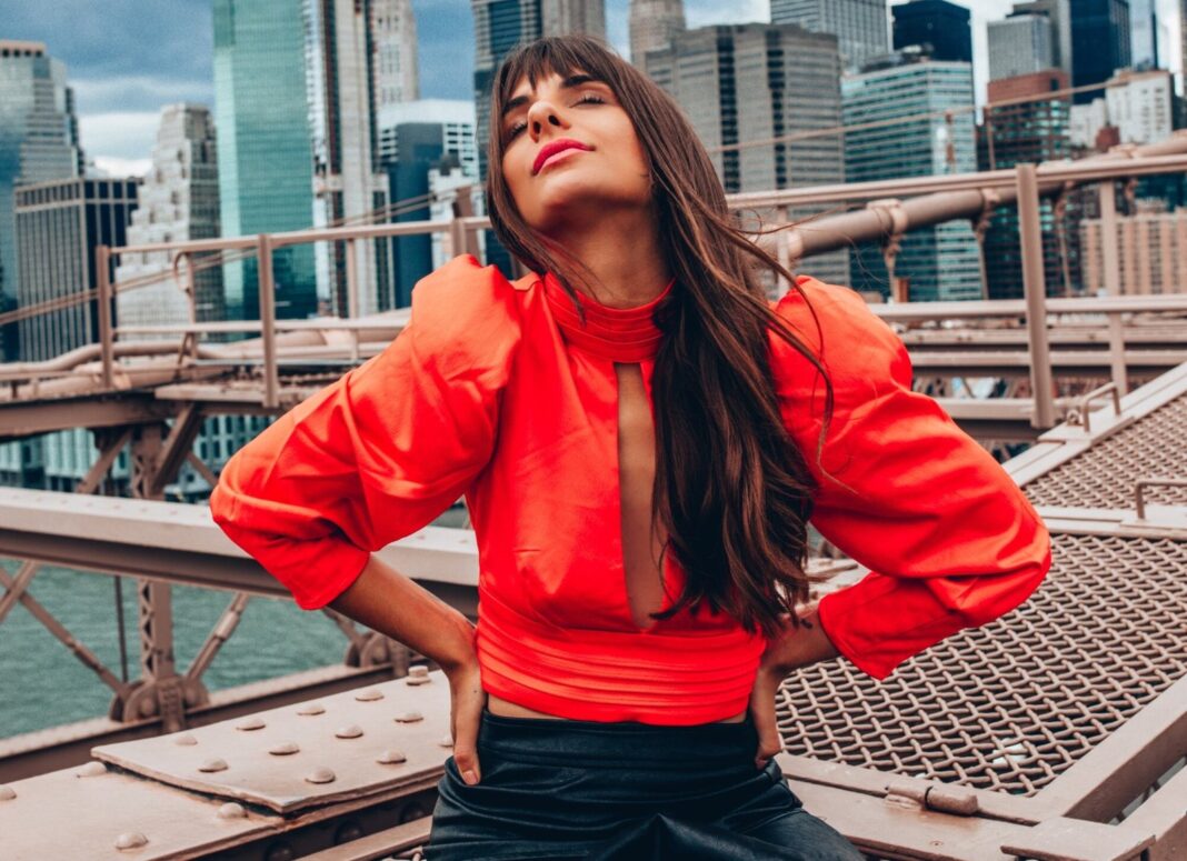Drea León junto a una carpa bell tent en un paisaje natural