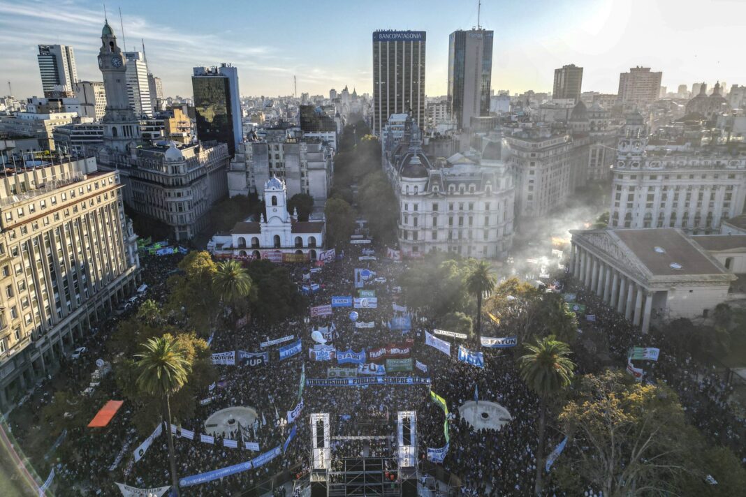 Multitud en la Marcha Federal Universitaria con banderas y carteles