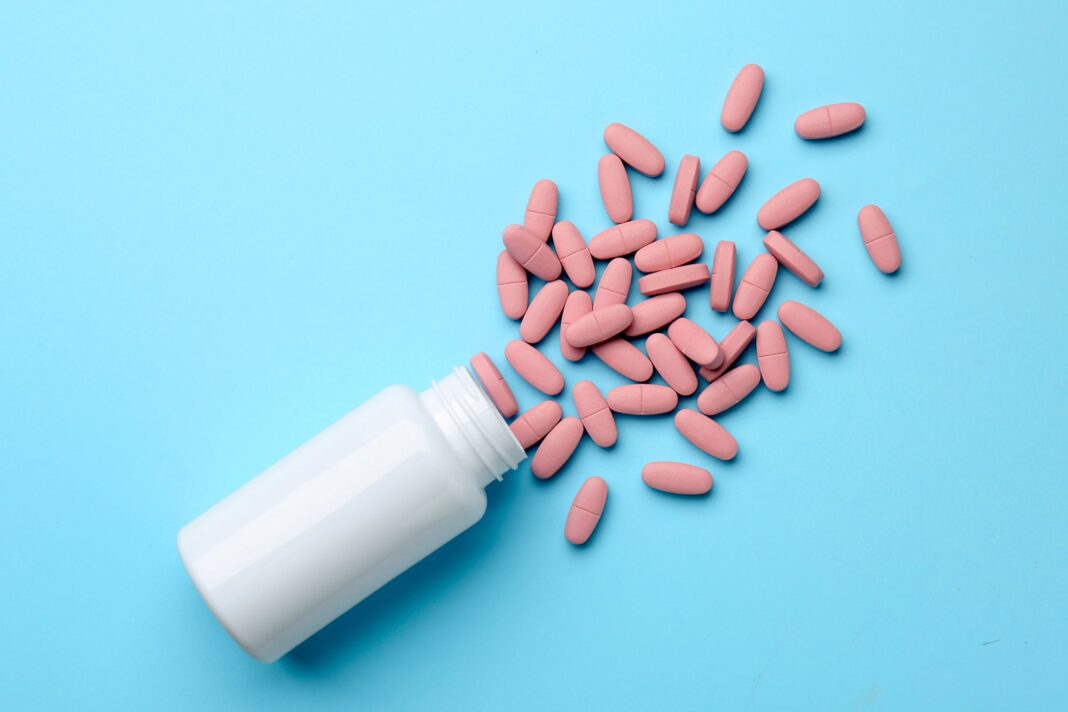 Niño sosteniendo frascos de suplementos vitamínicos en un entorno hogareño