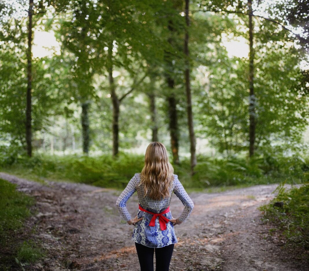 Persona sentada en posición de meditación con fondo de paisaje natural