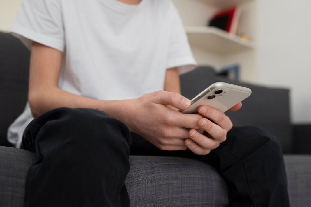 Joven usando un chatbot de inteligencia artificial en un dispositivo móvil