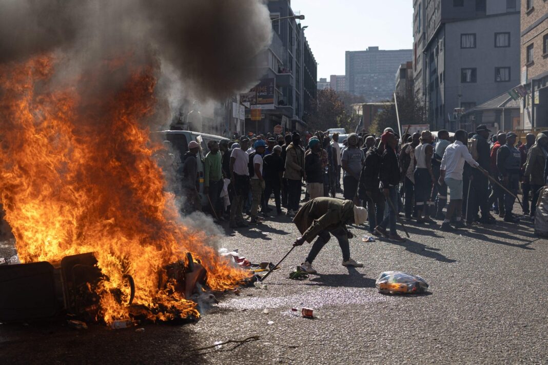 Manifestantes con carteles en una protesta contra inmigrantes en Sudáfrica