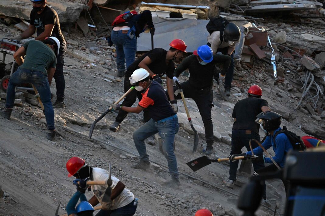 Voluntarios removiendo escombros con pico y pala en La Guaira tras el terremoto en Venezuela