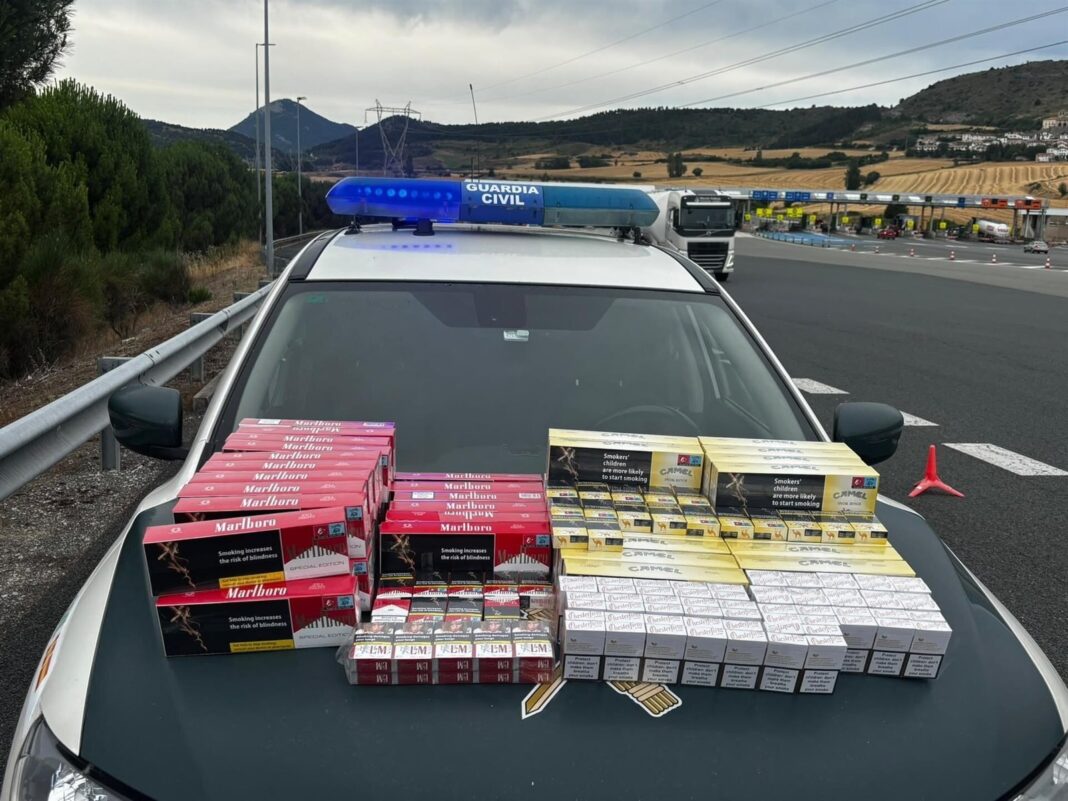 Agentes de la Guardia Civil revisan cajetillas de tabaco incautadas en el peaje de Zuasti