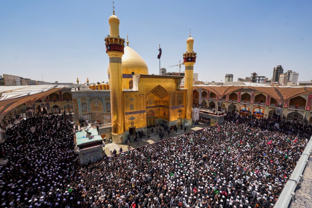 Multitud portando retratos de Khamenei y banderas iraníes durante la procesión fúnebre en Nayaf