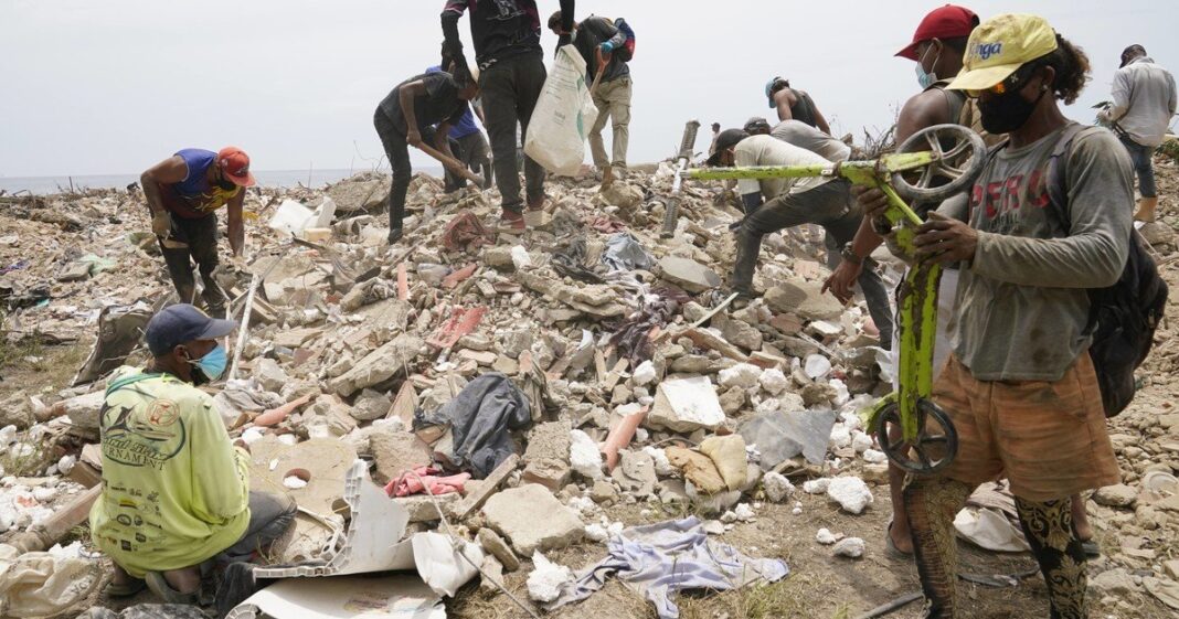 Personas revuelven escombros en un descampado de La Guaira tras los terremotos en Venezuela