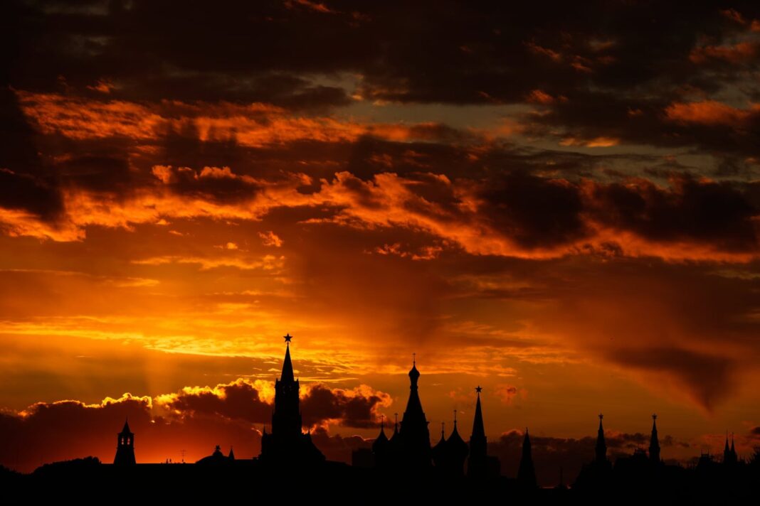 Silueta de un palacio histórico al atardecer con cielo rojizo y naranja