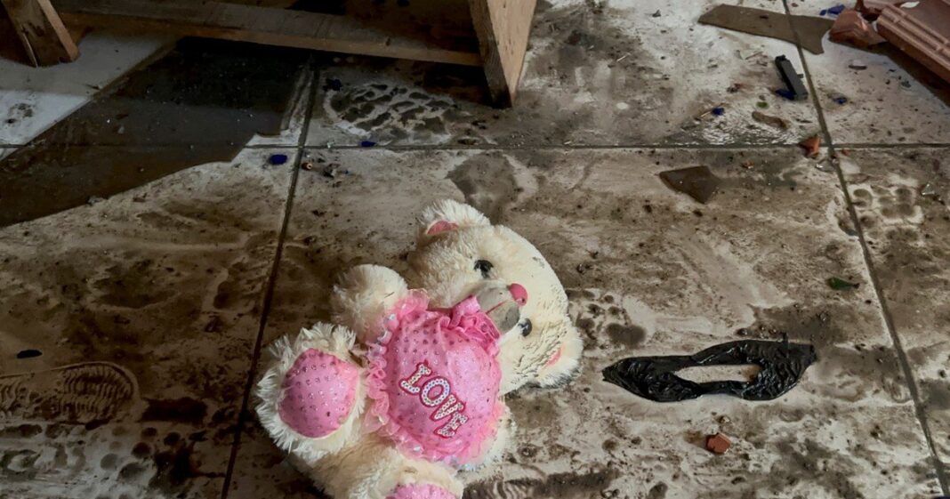 Niño sosteniendo un juguete entre escombros en una zona afectada por un ataque