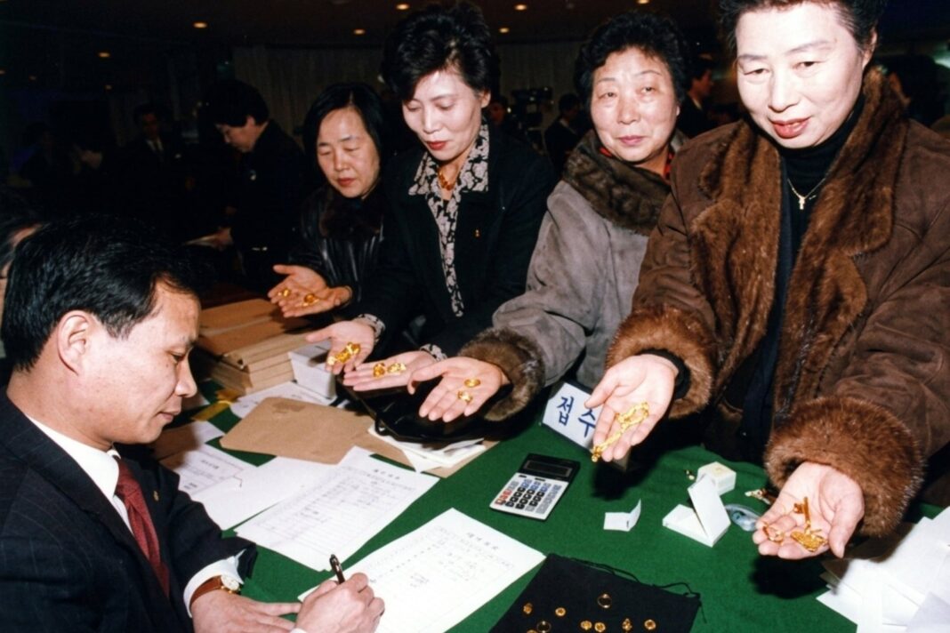 Personas entregando joyas de oro durante la colecta en Corea del Sur en 1998