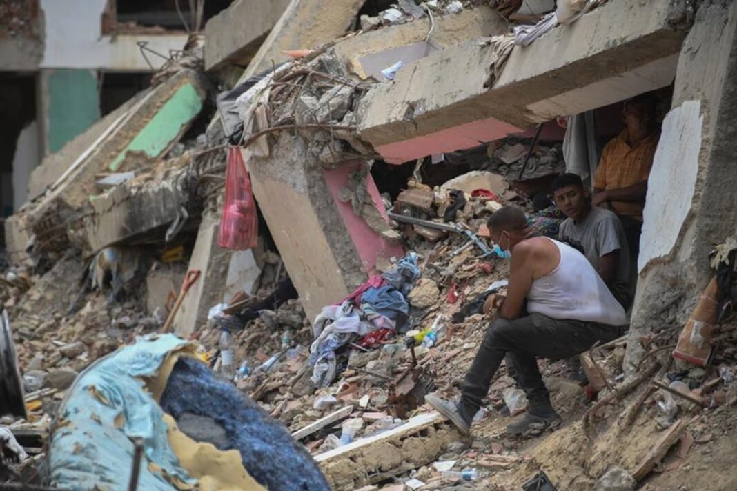 Personas sentadas sobre los escombros de un edificio colapsado en Caraballeda, Venezuela