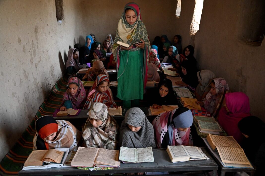 Niñas afganas leyendo libros en un aula en Kandahar, Afganistán