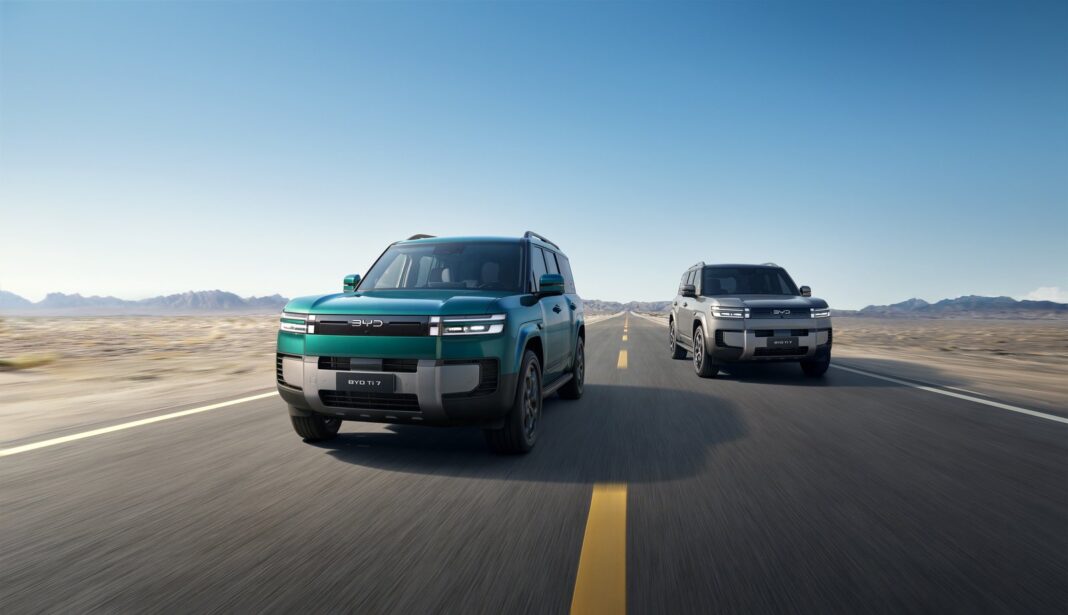 SUV híbrido BYD Ti7 en color claro, visto de frente en un camino de tierra