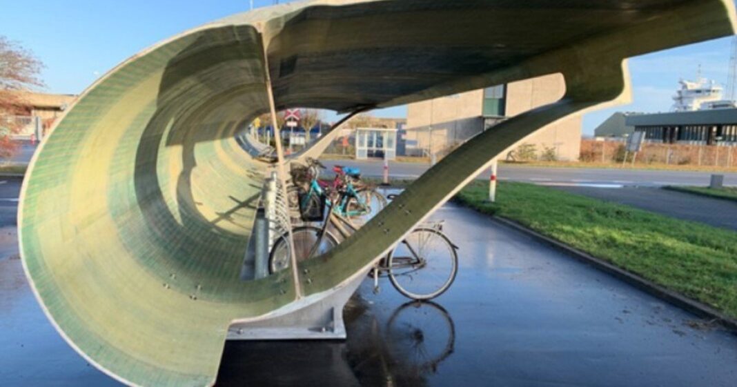 Pala de aerogenerador reutilizada como techo de aparcamiento para bicicletas en Aalborg, Dinamarca