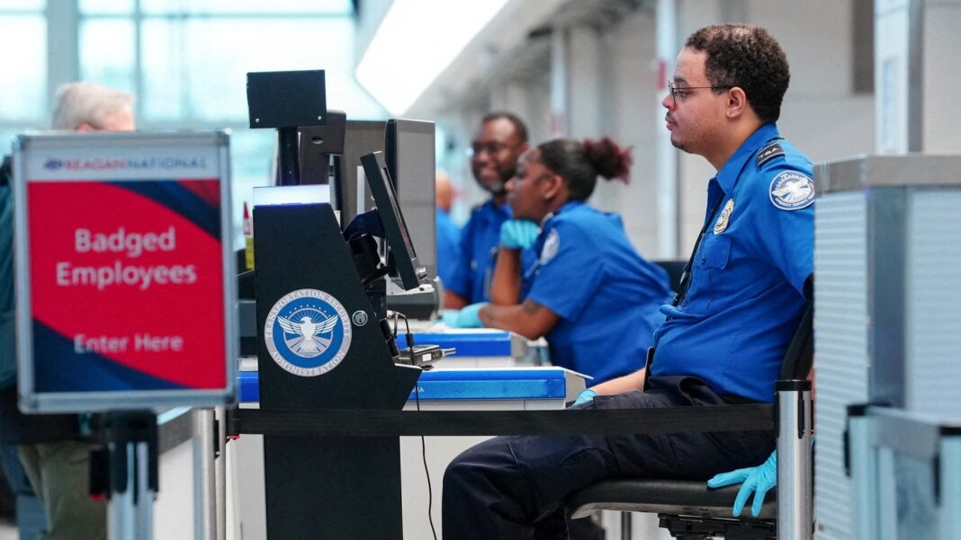 Agente de la TSA de pie en un control de seguridad de un aeropuerto
