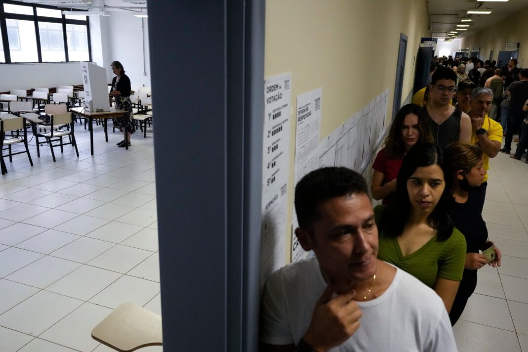 Urna electrónica con la bandera de Brasil de fondo, en el contexto de las elecciones presidenciales de 2026