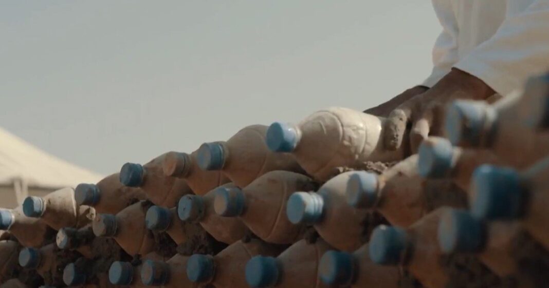 Tateh Lehbib Breica frente a una de las viviendas construidas con botellas de arena en el campamento de refugiados de Awserd, Argelia